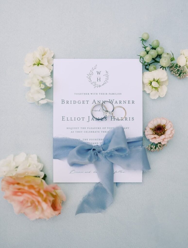 Elegant wedding invitation with dusty blue bow