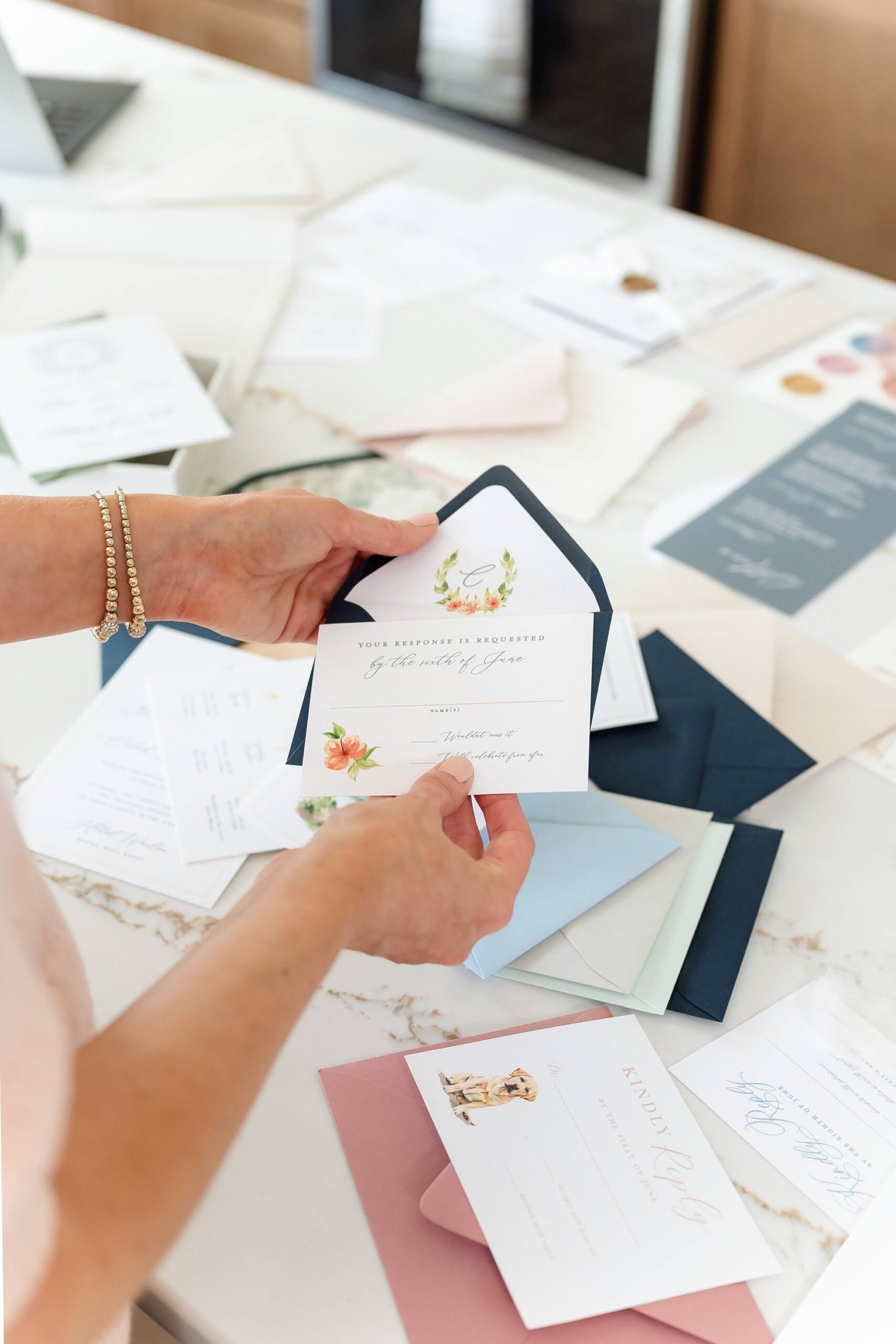 Wedding stationer holds an RSVP card