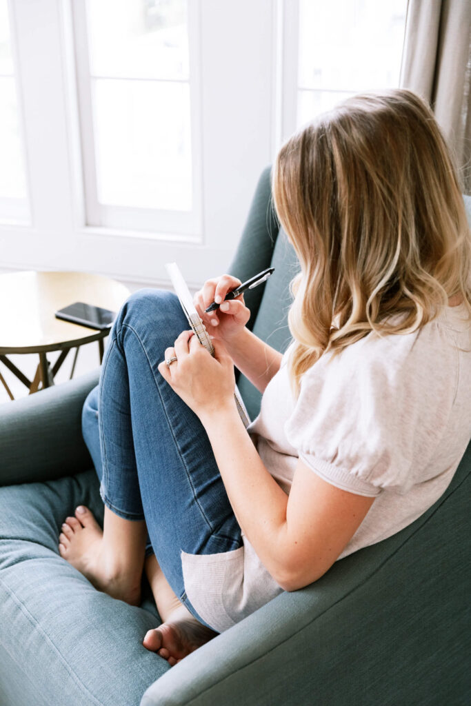 Woman writing out a to do list for addressing her wedding invitations