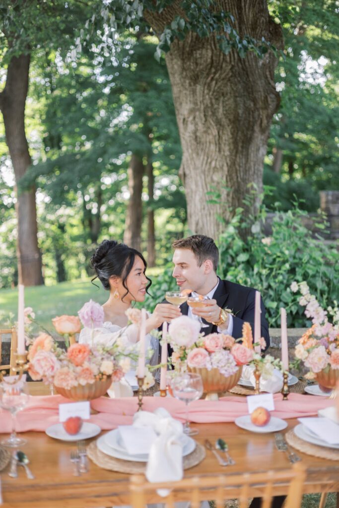 Couples clinking glasses of a peach drink on their wedding day at Tyler Gardens. 