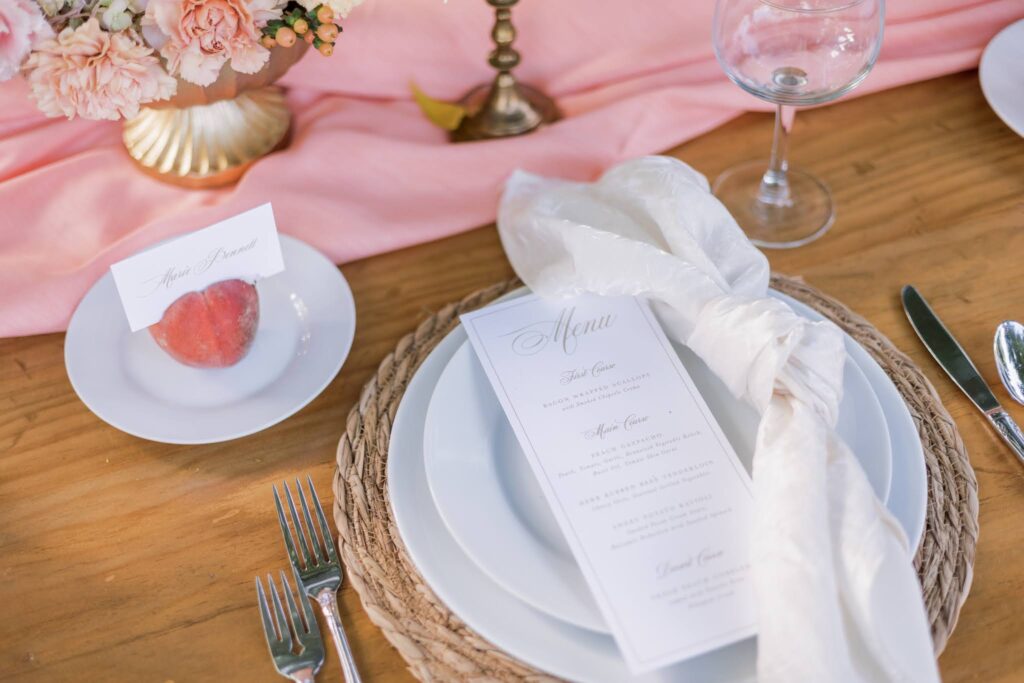 Menu for summer garden wedding at Tyler Gardens. Escort card is placed in a peach next to each place setting.