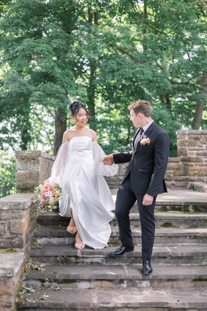 Couple walking down the steps while holding hands on their wedding day at Tyler Gardens