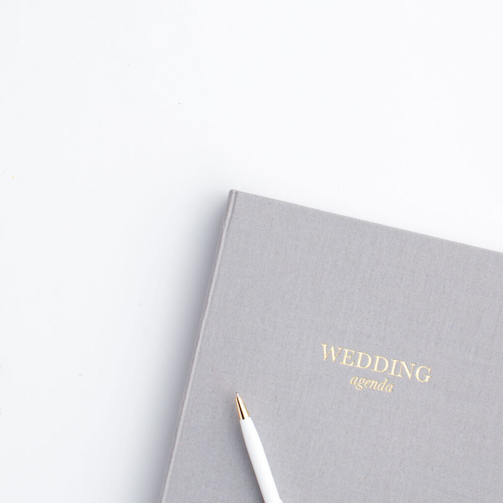 Gray notebook labeled "wedding agenda" to be used to help plan a wedding and keep wedding notes organized during wedding planning