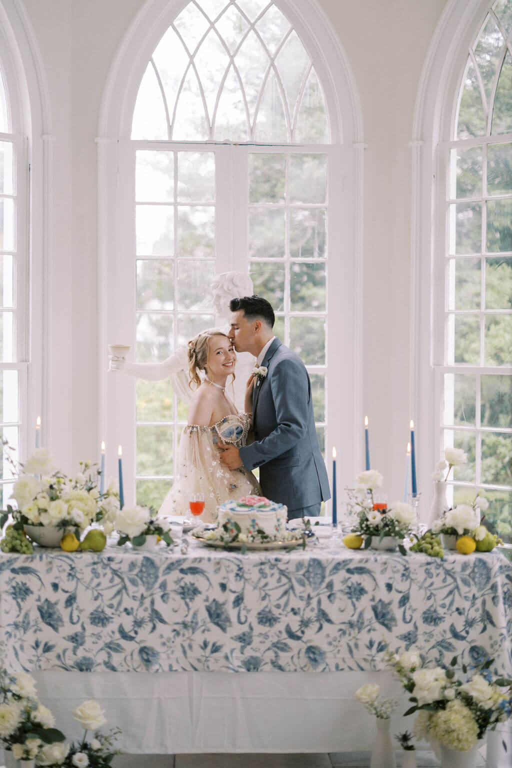 Man kissing bride at their sweetheart table for their vintage wedding reception at Linden Place