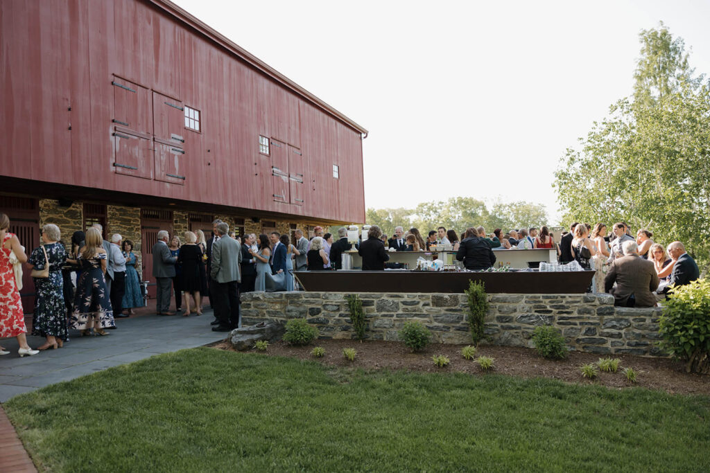 Guests gather for cocktail hour outside the barn at The Farm at Eagles Ridge