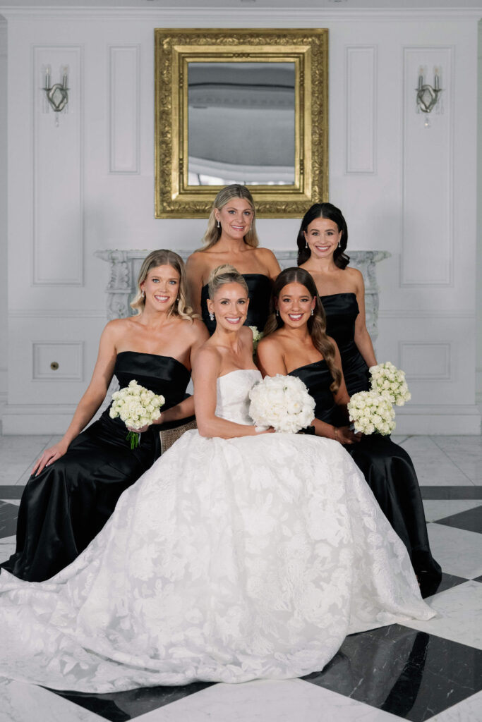 Elegant bride sitting with bridesmaids dressed in black