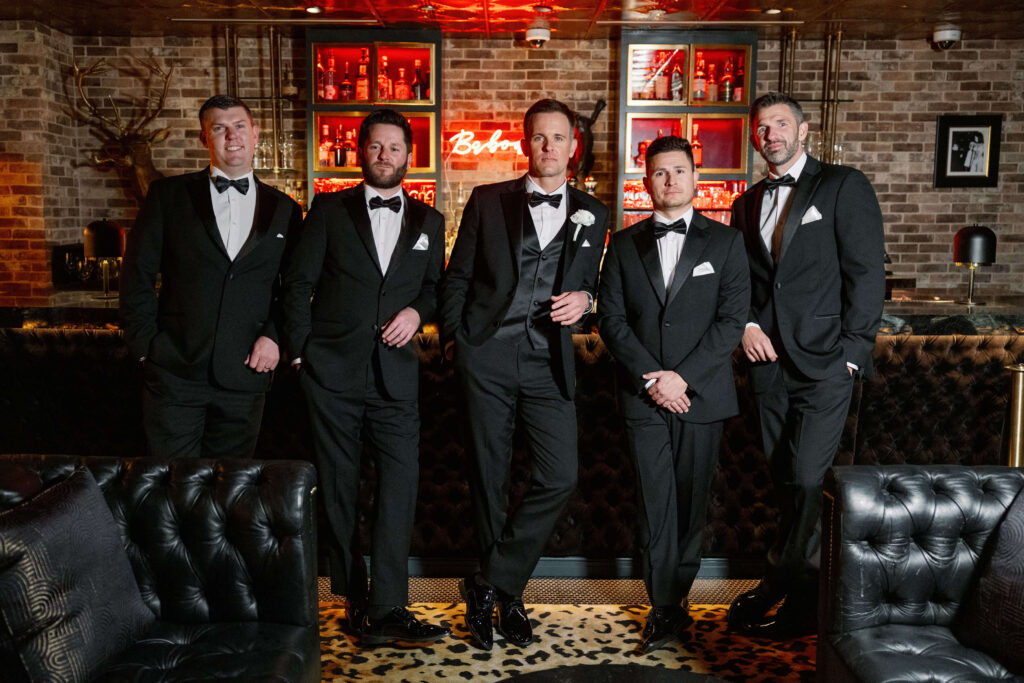 Groom with groomsmen posing in a bar