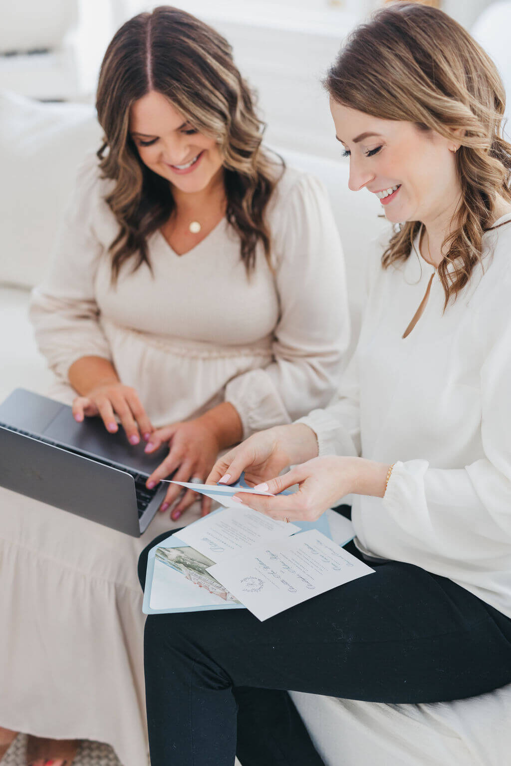 Stationery designers Heather and Emily holding a wedding invitation