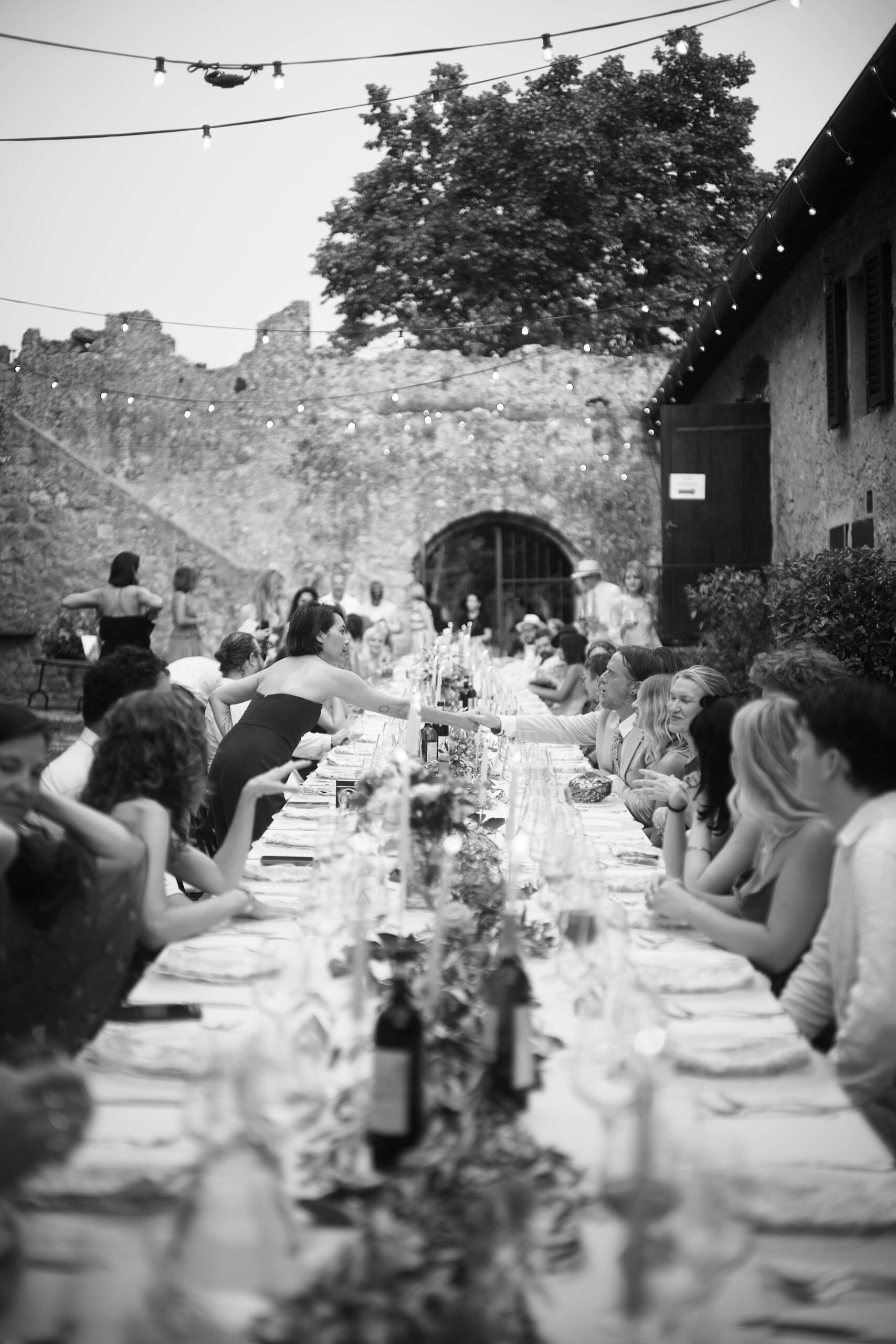 King table for outdoor wedding reception with greenery and florals