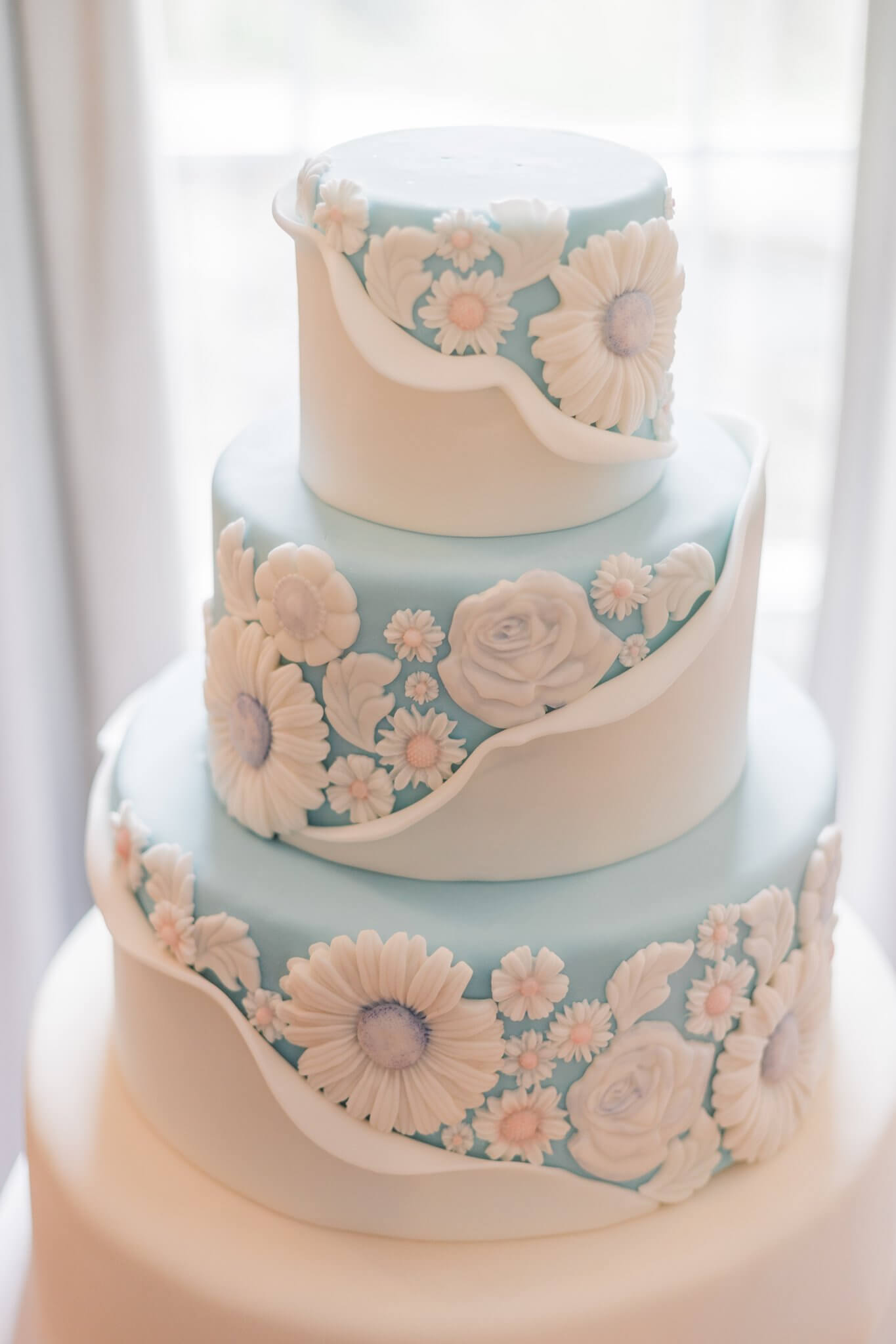 Elegant three-tiered wedding cake with floral designs