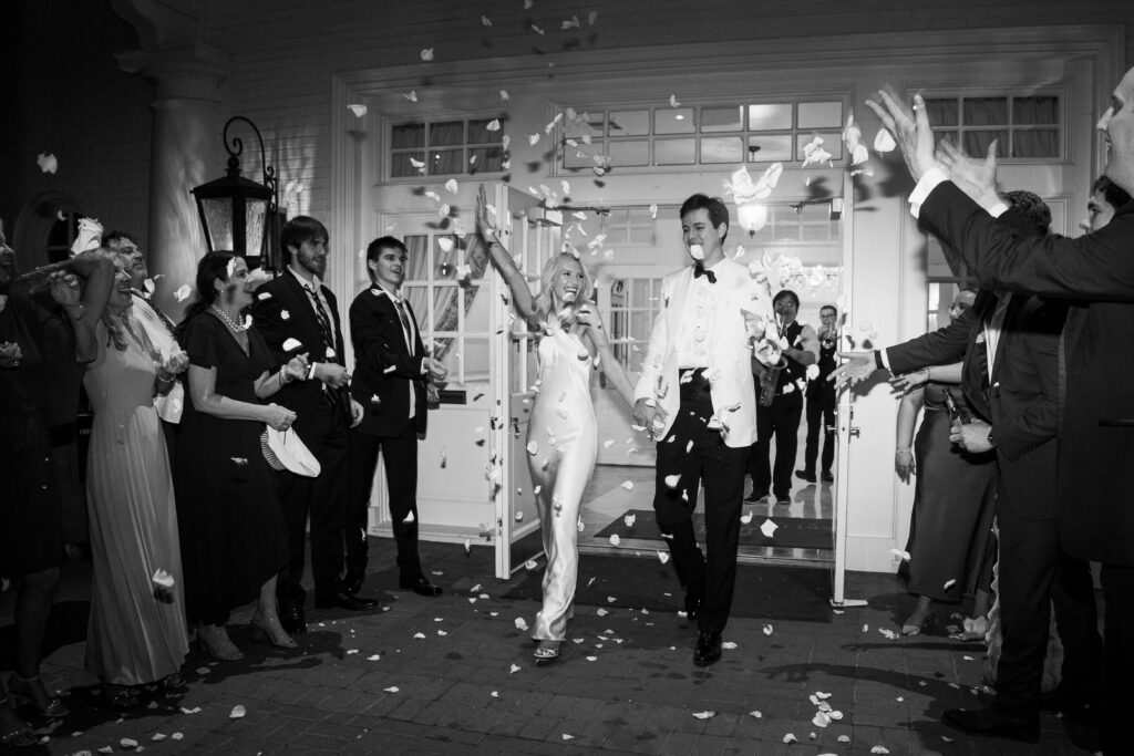 Bride and groom exiting the reception venue as guests throw confetti
