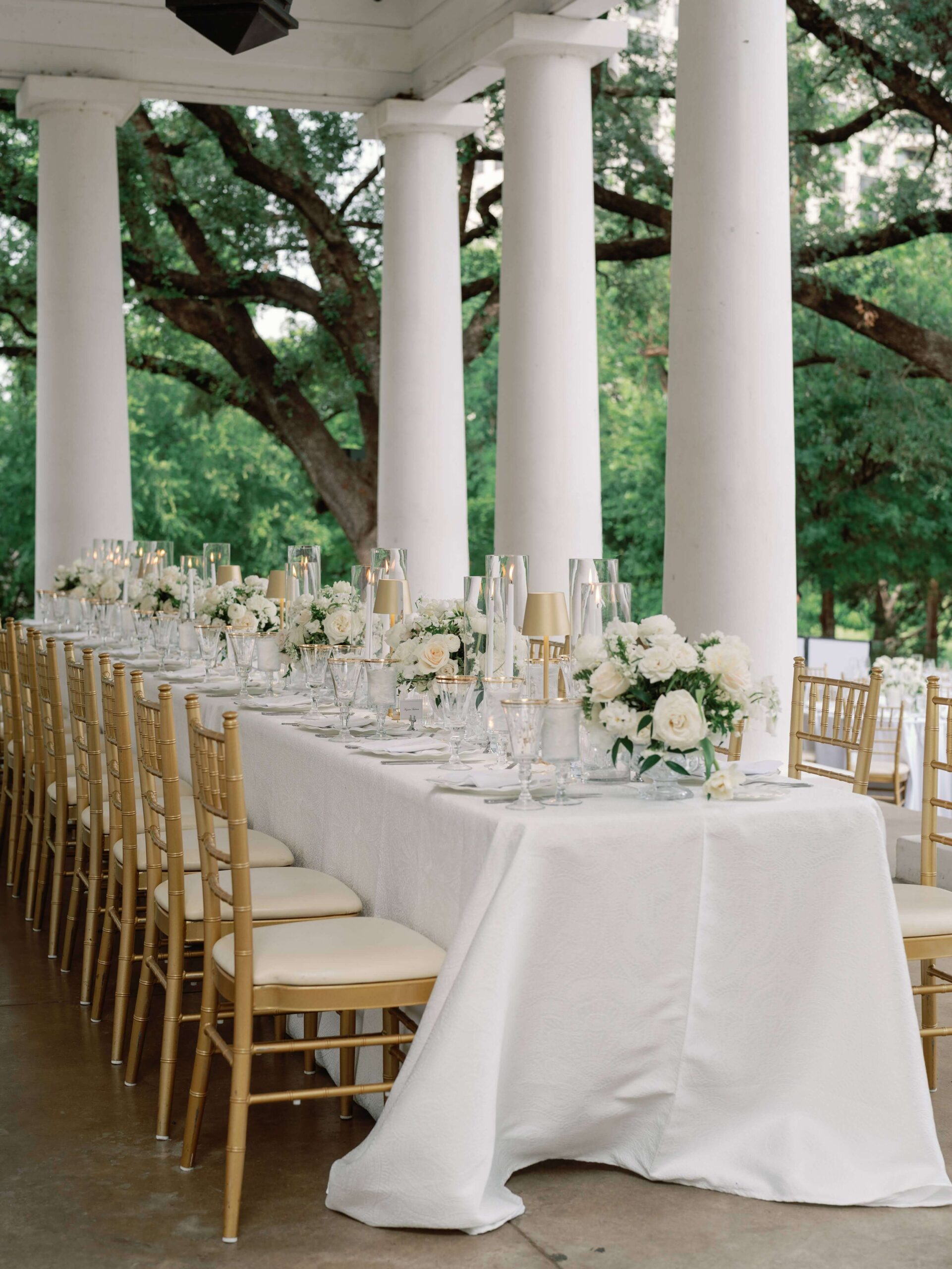 Elegant and classic white and gold wedding reception table with candles and roses