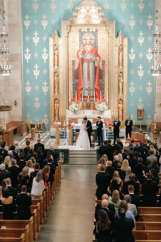 Bride and groom during wedding ceremony at ornate and grand Catholic church