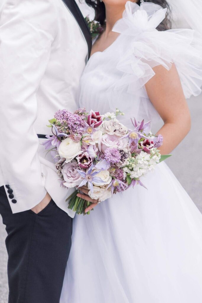 Bride holding purple bouquet