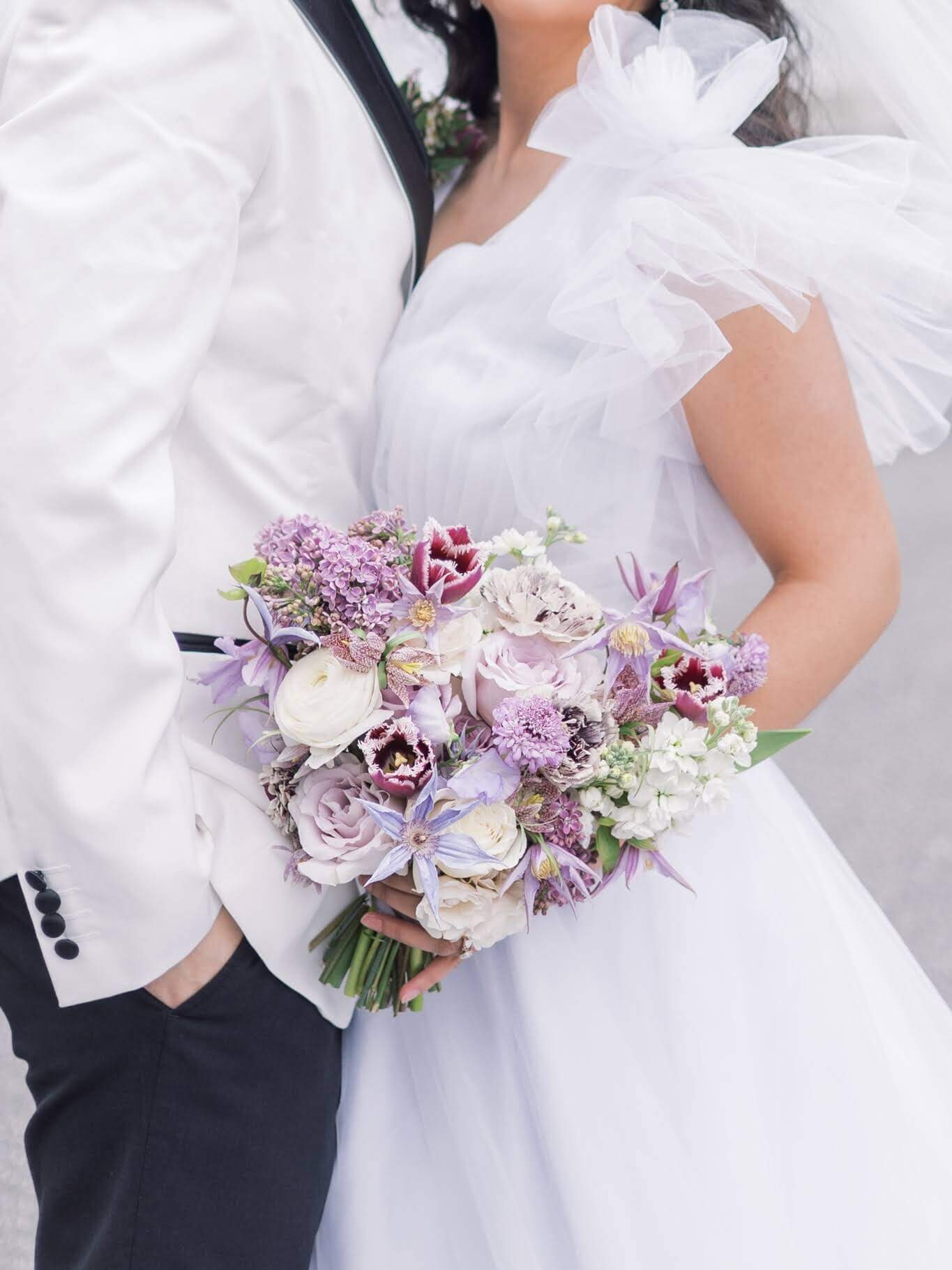 Bride holding purple bouquet