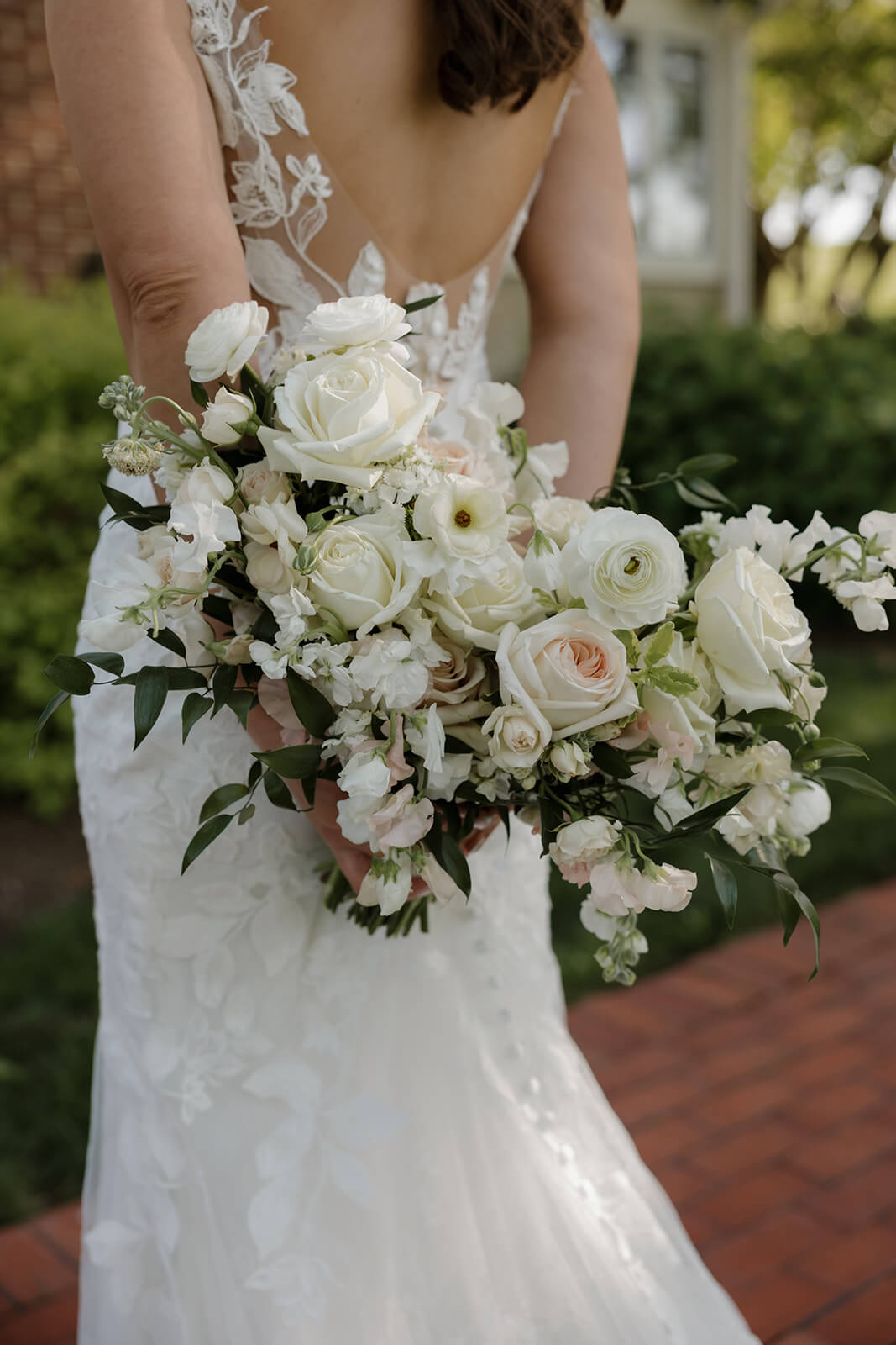 Bride holding elegant white and blush bouquet of roses