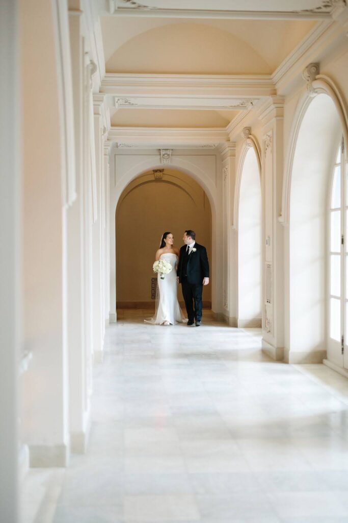 Bride and groom walk down hallway of Elkins Estate