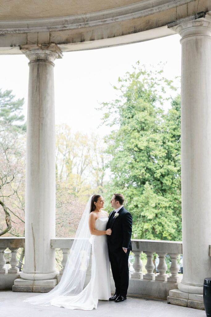 Bride and groom gaze at each other on a balcony at Elkins Estate