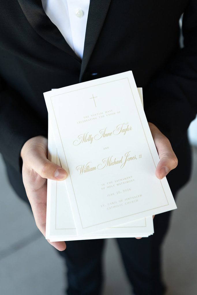Front of a white and gold wedding ceremony program card for a church ceremony