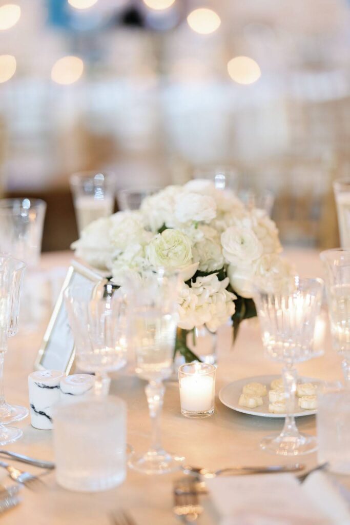 Low white floral arrangement on wedding reception table