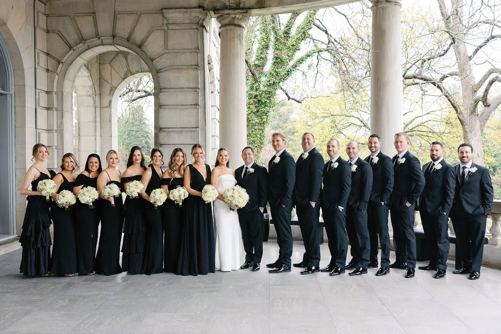 Portrait of the bride and groom with their entire wedding party, all dressed in black and white