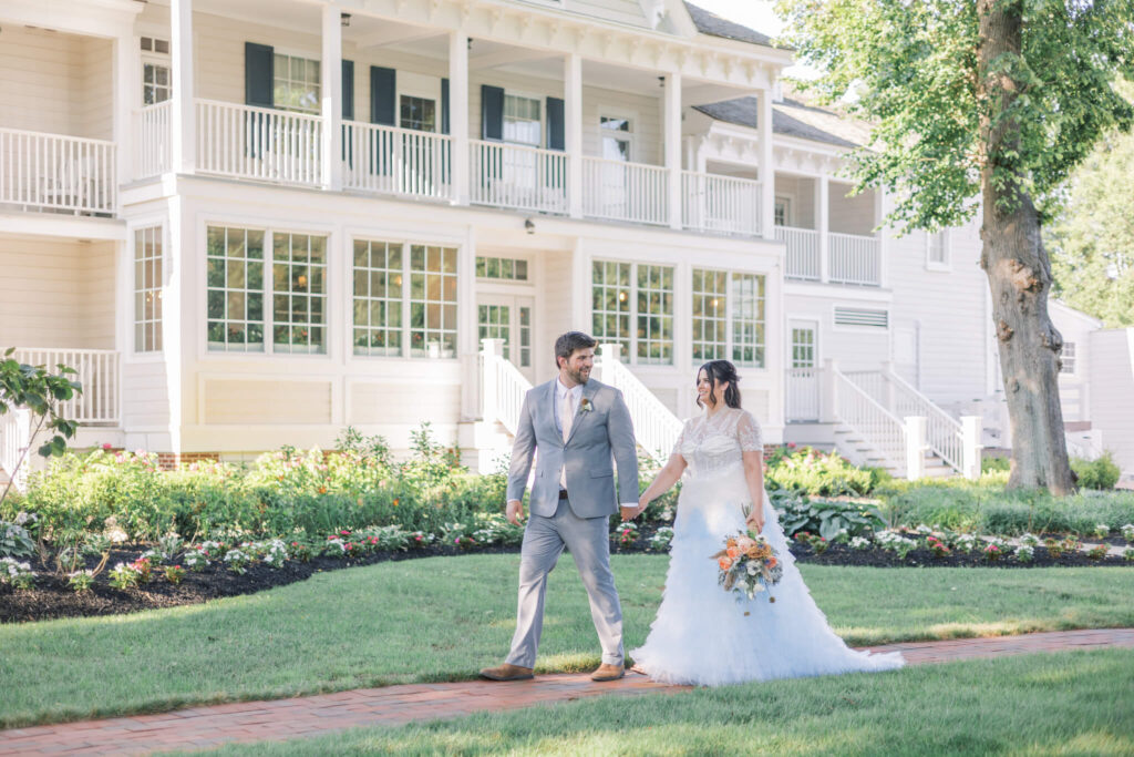 Bride and groom stroll the grounds of Kent Island Resort on their wedding day