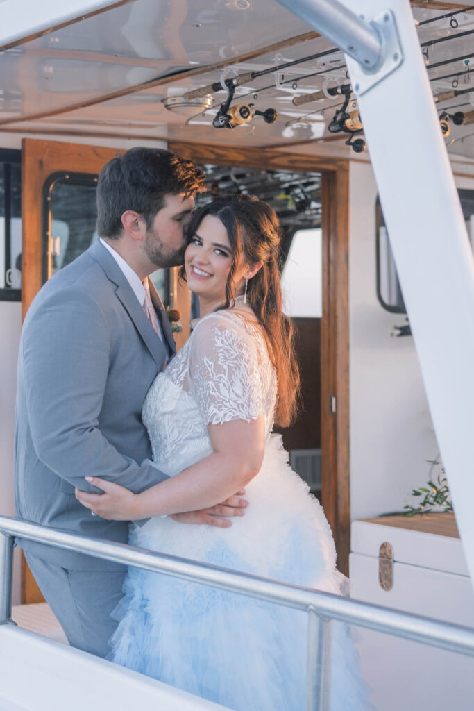 Bride and groom embrace on a sunset cruise in Maryland