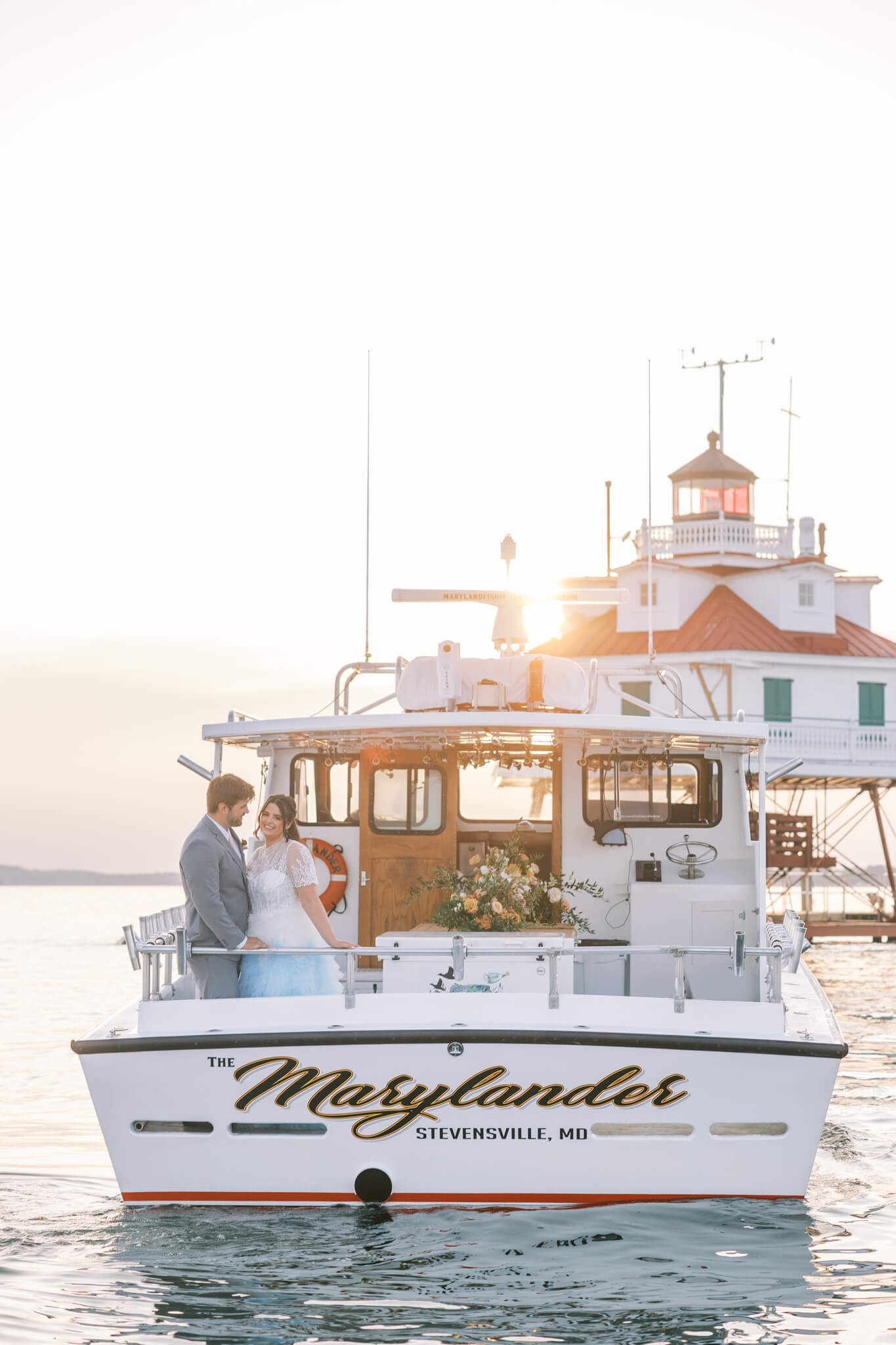 Bride and groom take a sunset cruise around the bay on a boat called The Marylander