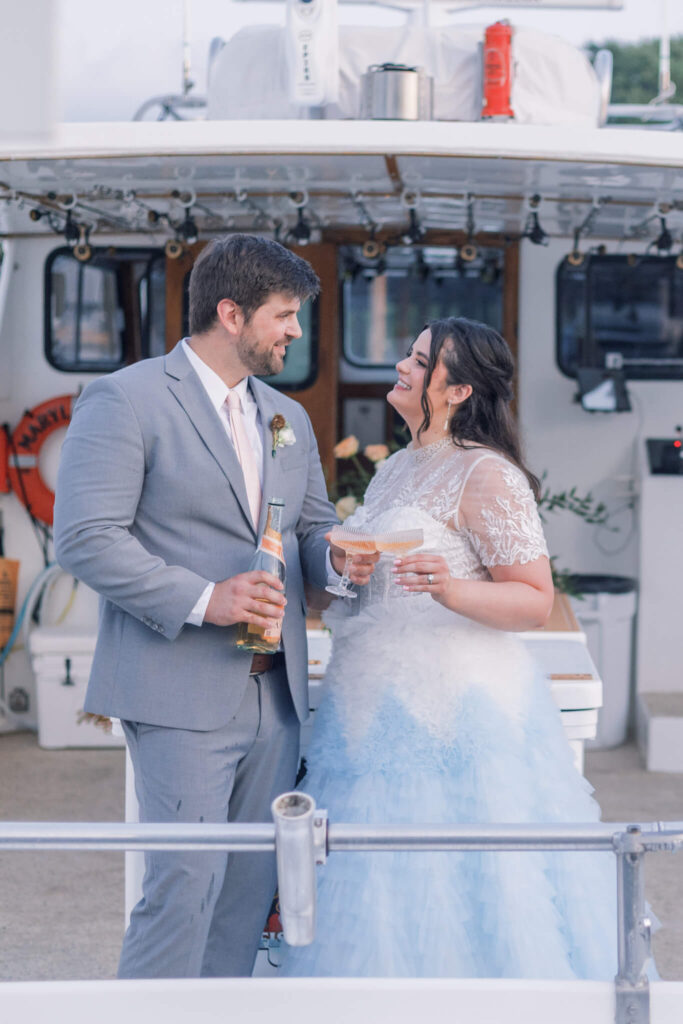Bride and groom champagne toast on a boat at sunset