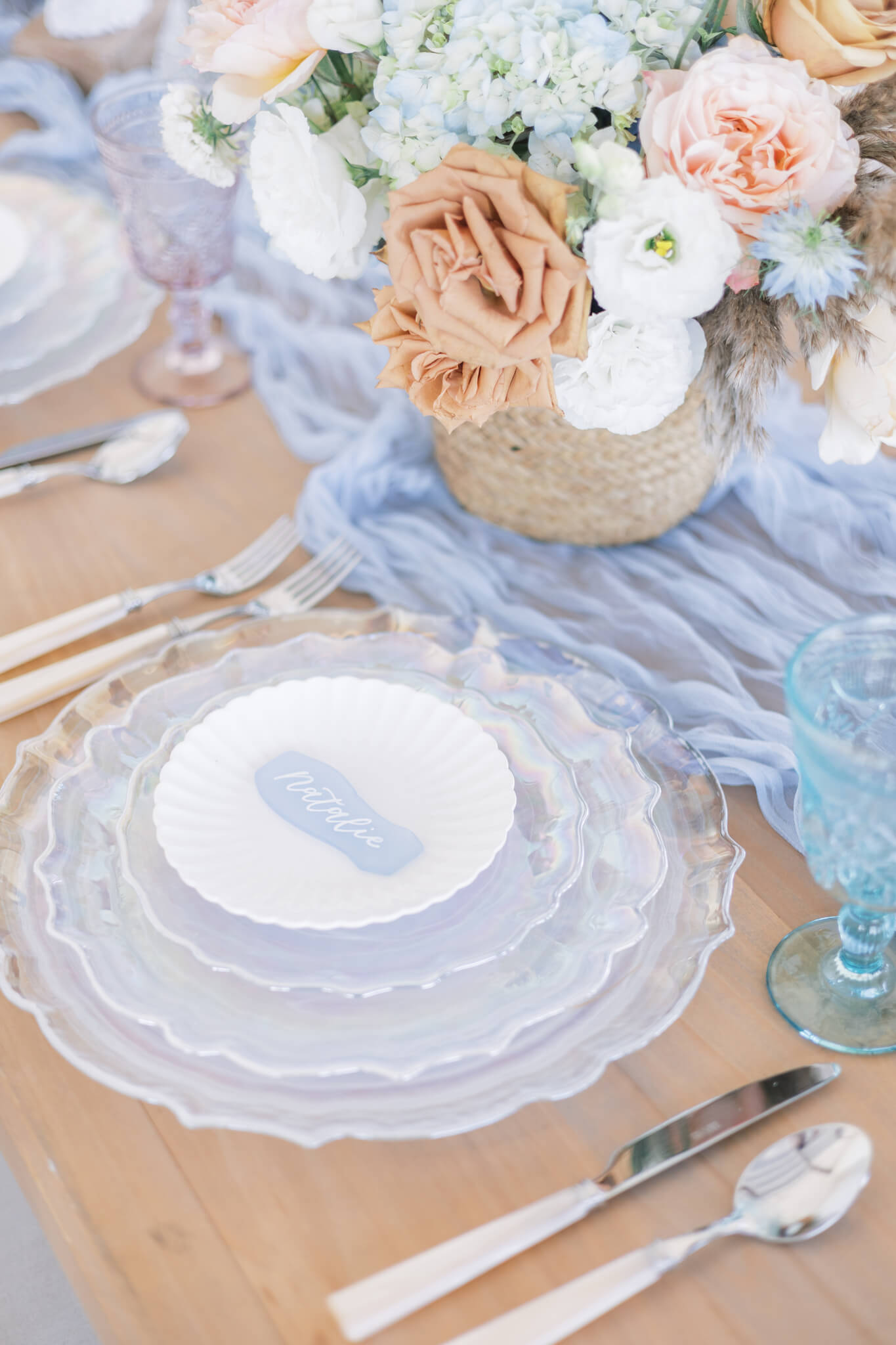 Sea glass calligraphed place card atop iridescent plate stack