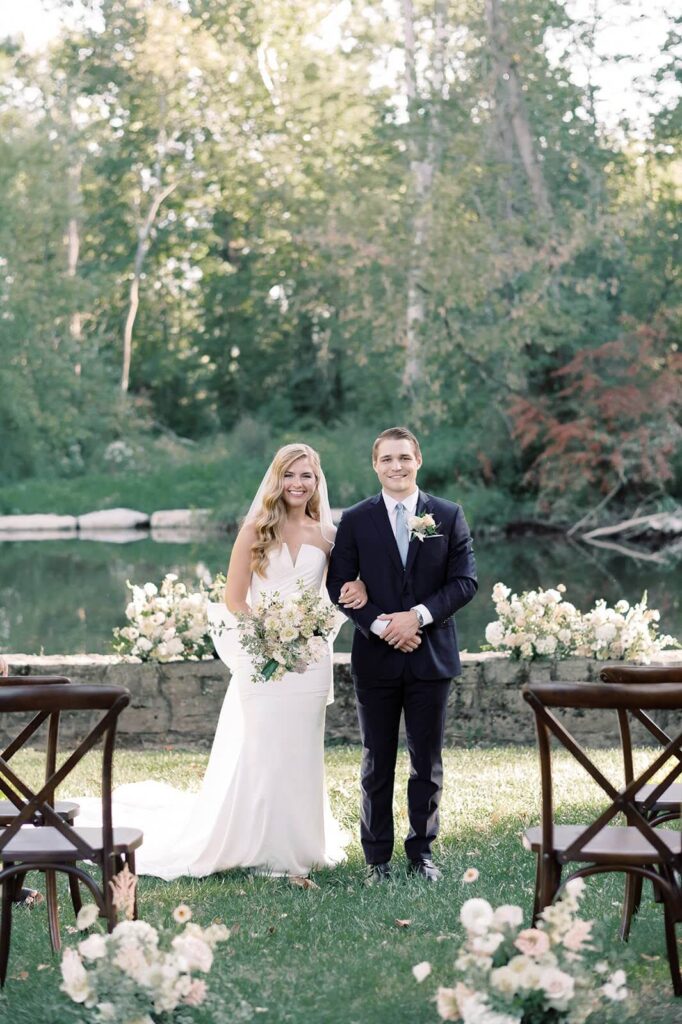 Bride and groom stand for a portrait where their ceremony was located, on the banks of the Yellow Breeches