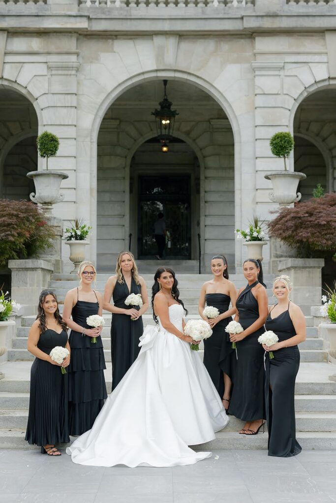 Bride and bridesmaids, wearing sleek black formal dresses