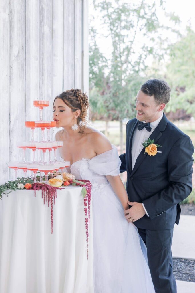 Bride sips strawberry champagne from a champagne tower