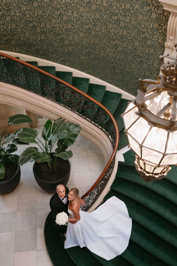 Bride and groom descend the grand staircase in Elkins Estate