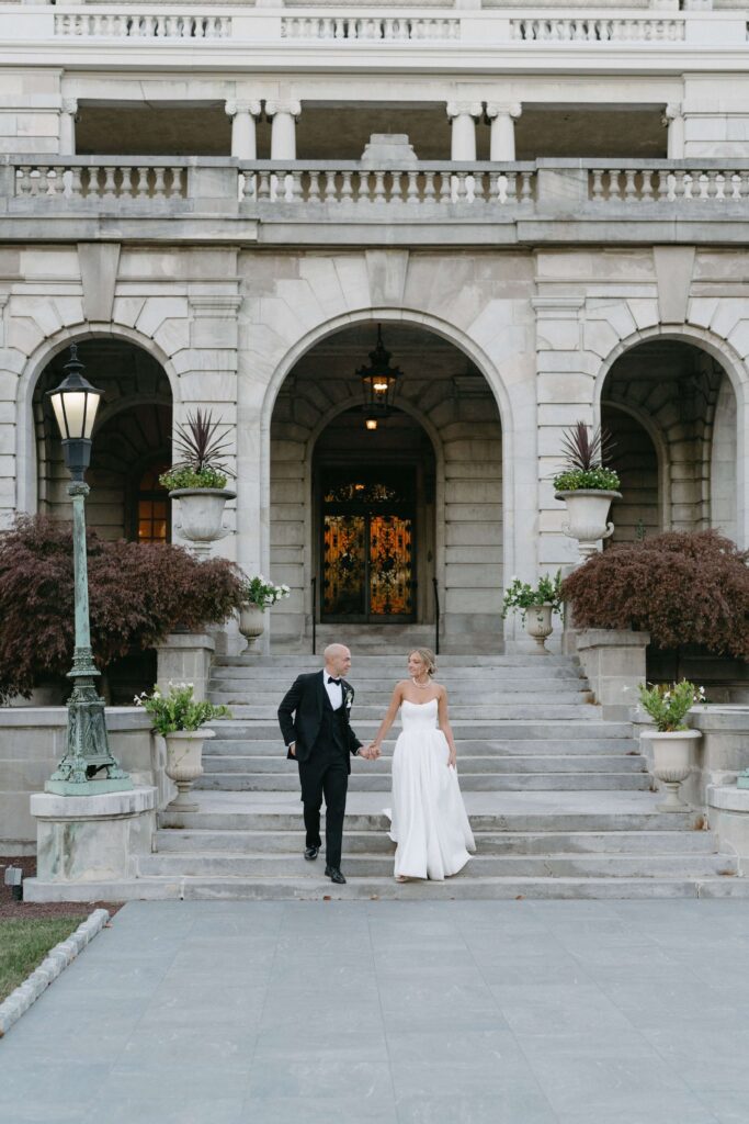 Bride and groom exit Elkins Estate holding hands