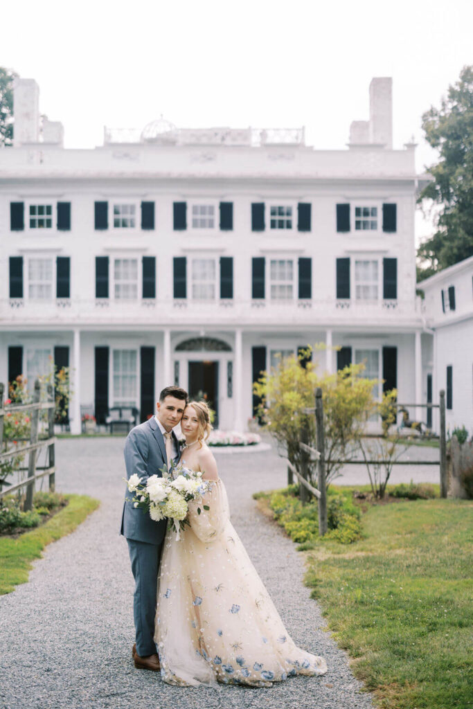 Bride and groom pose in front of Linden Place, a historic East Coast wedding venue