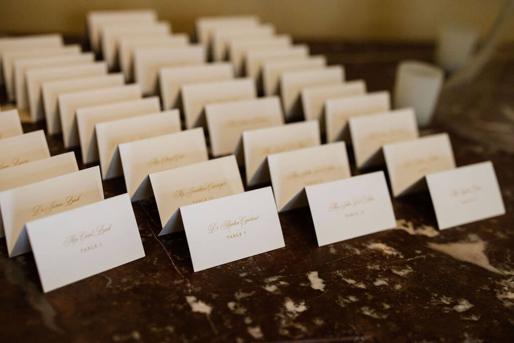 Elegant white and gold tented escort cards on display