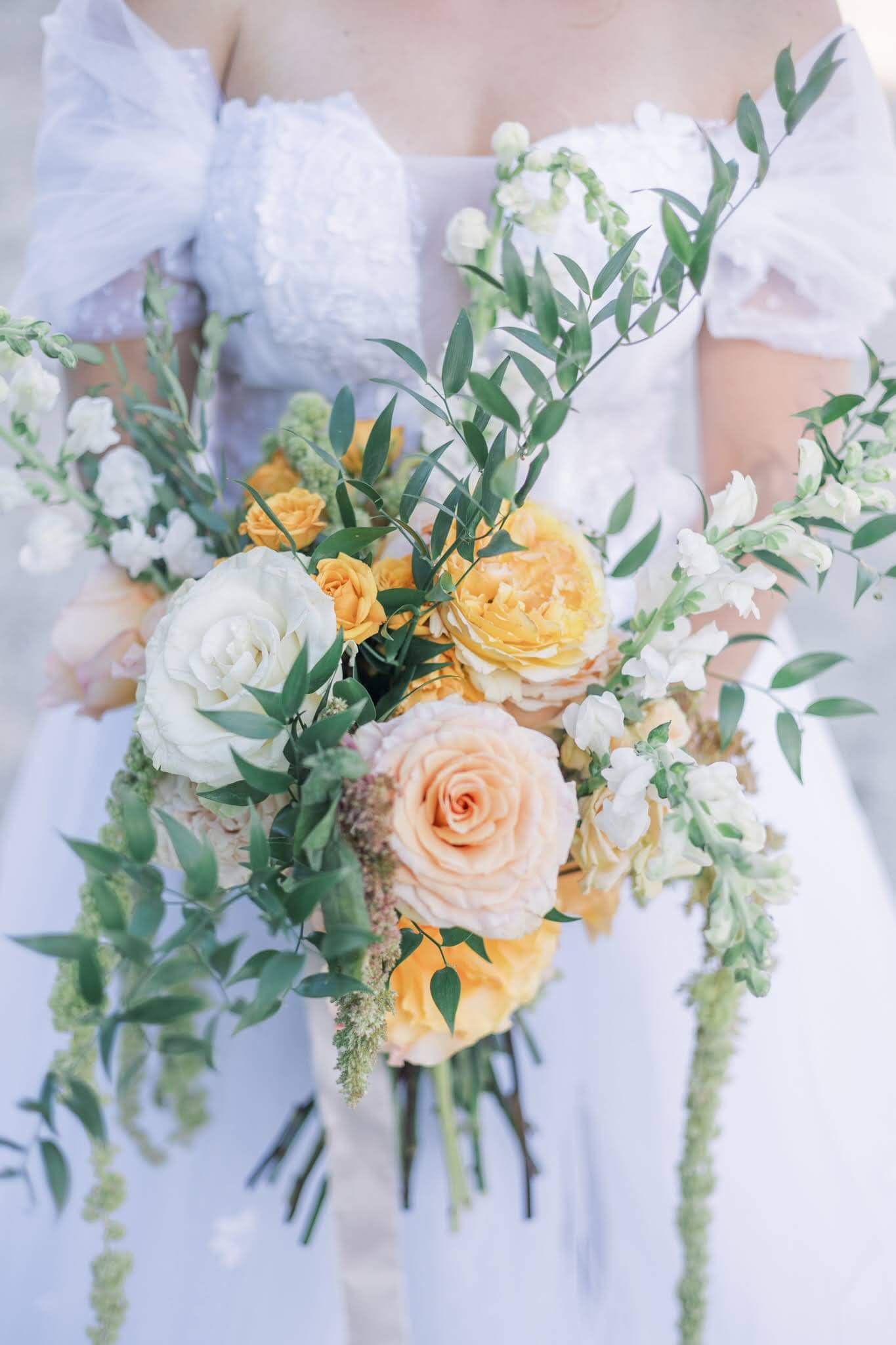Elegant orange bridal wedding bouquet with trailing greenery