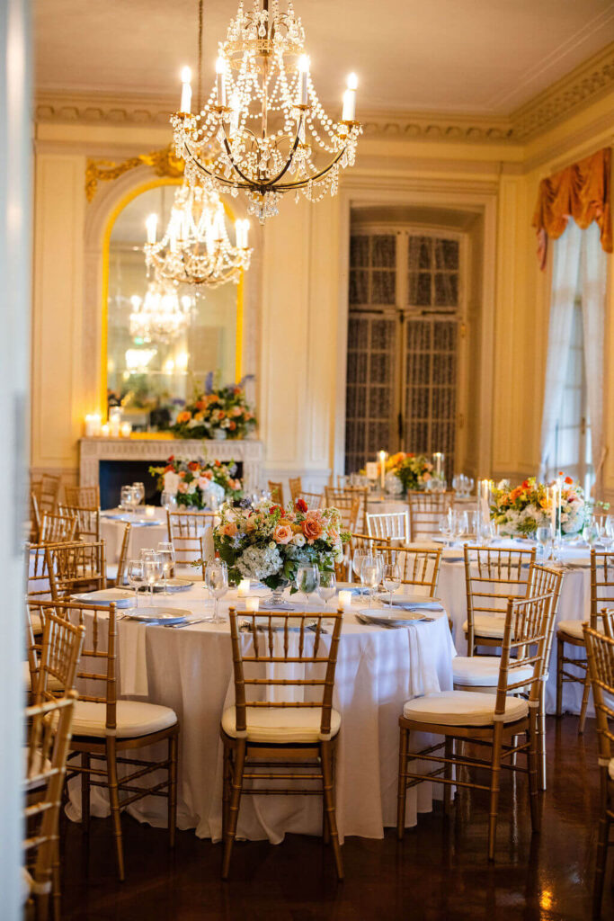 Elegant wedding reception tables in a grand room at Glen Manor House with chandeliers and gold Chiavari chairs