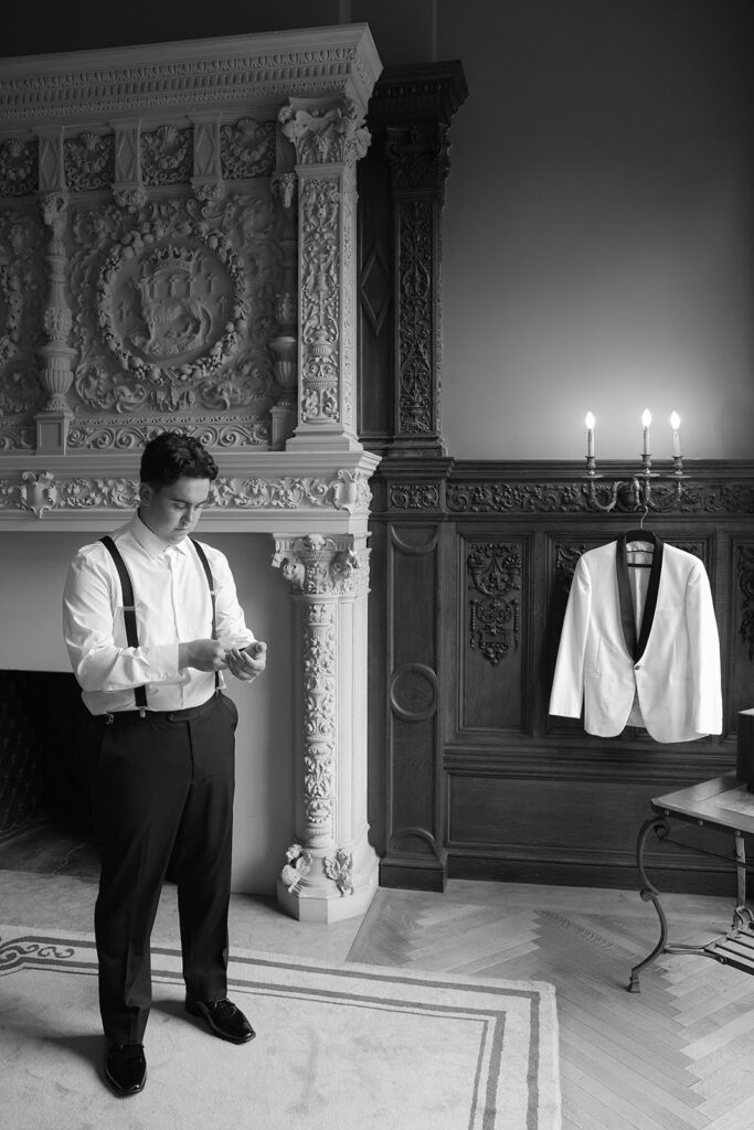 Groom putting on his tux on the morning of his wedding