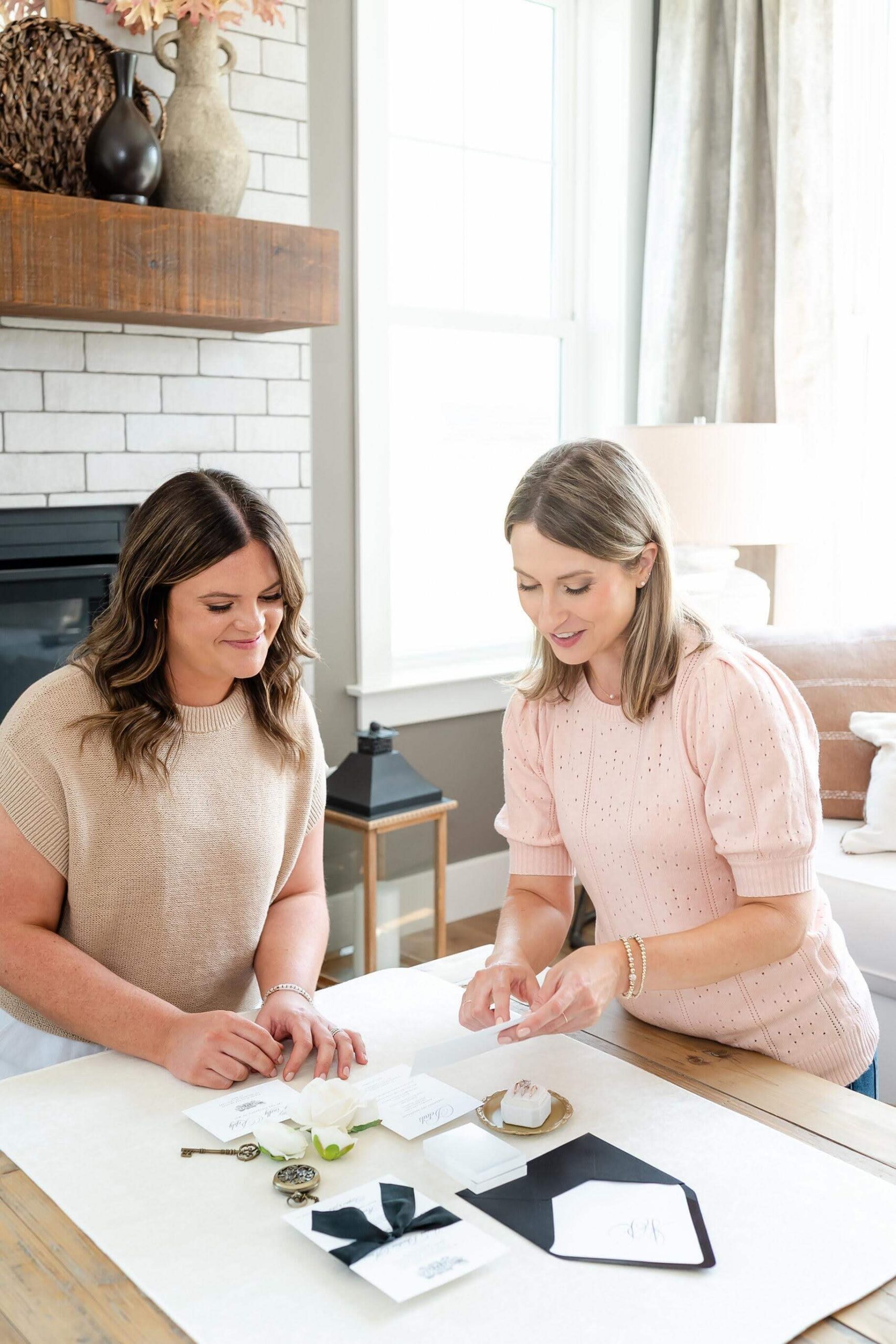 Heather Paperie co-owners discussing Jaimi and Ryan's custom wedding invitation experience and pointing at their suite