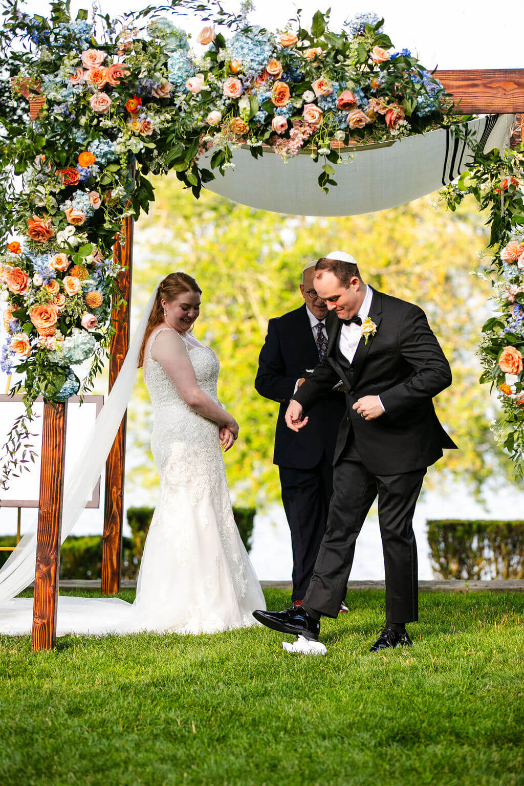 Groom wearing a kippah steps on wedding glass during Jewish wedding ceremony