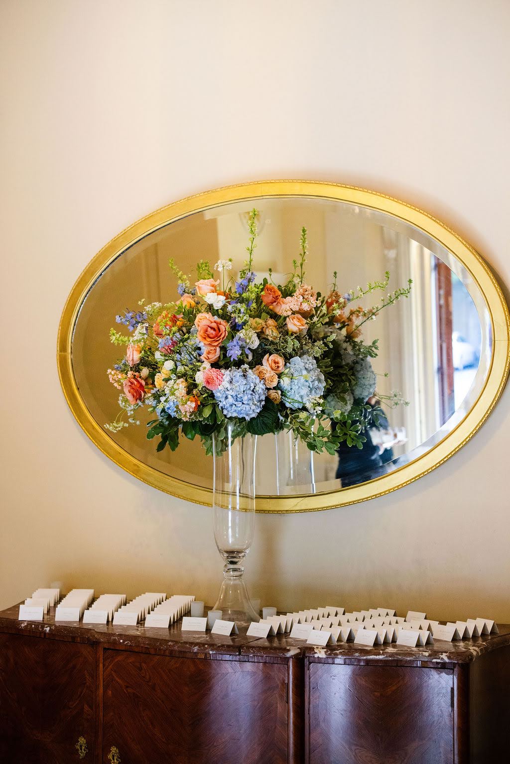 Tented escort card display on display table with colorful flowers
