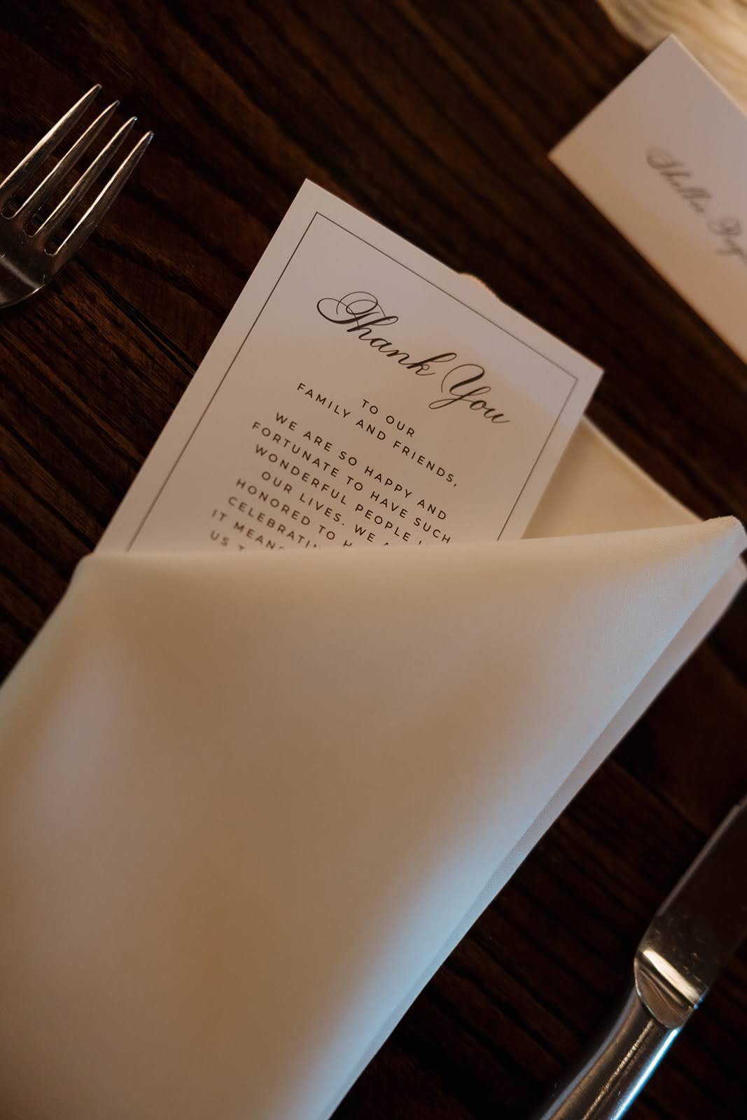 Thank you card tucked into guest's napkin at wedding reception