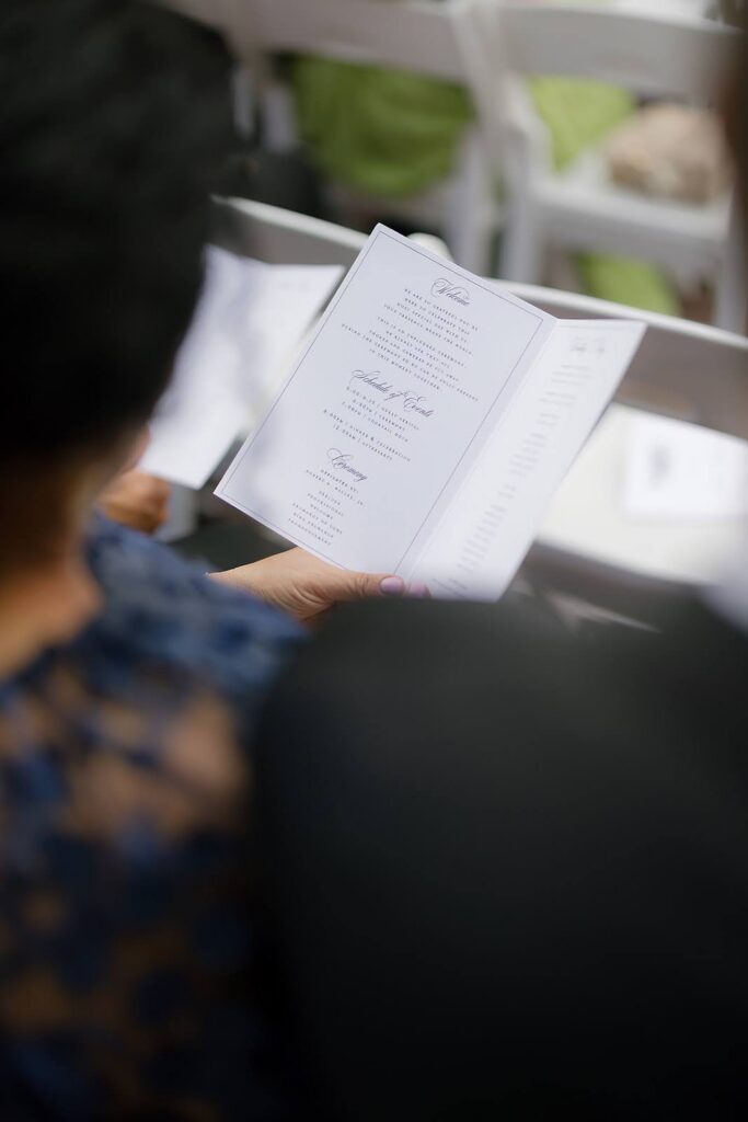 Wedding guest reading a wedding ceremony program booklet