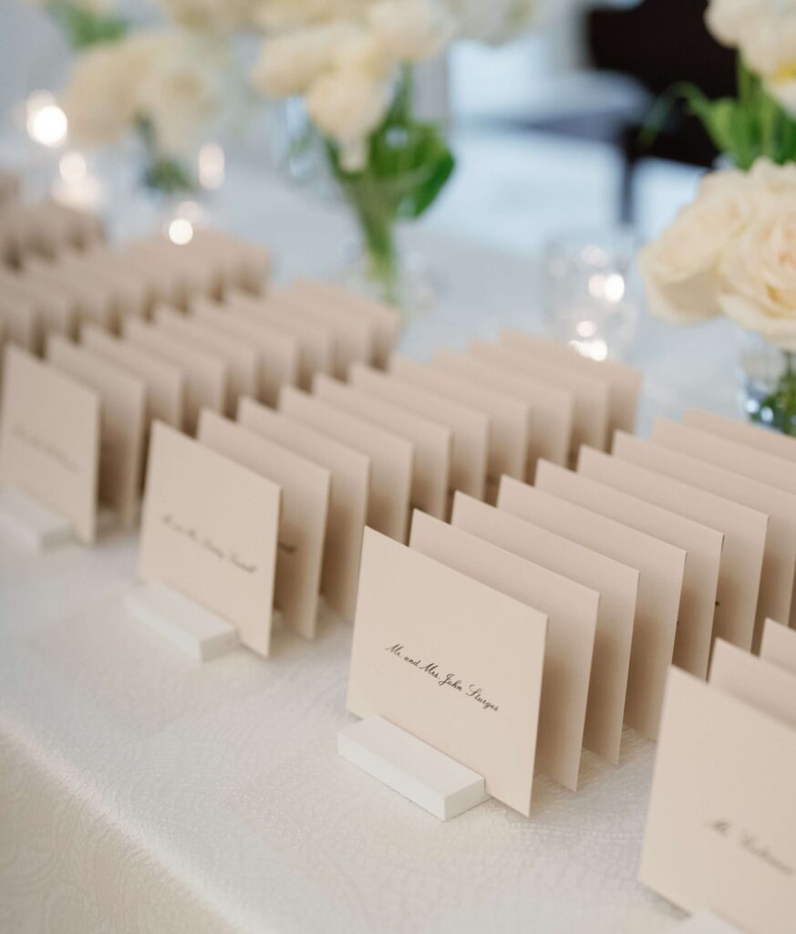 Wedding escort card display of cream envelopes organized by name