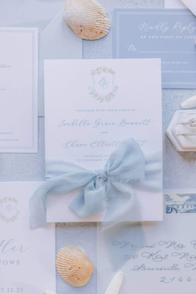Romantic coastal wedding invitation card with blue silk ribbon and custom floral monogram