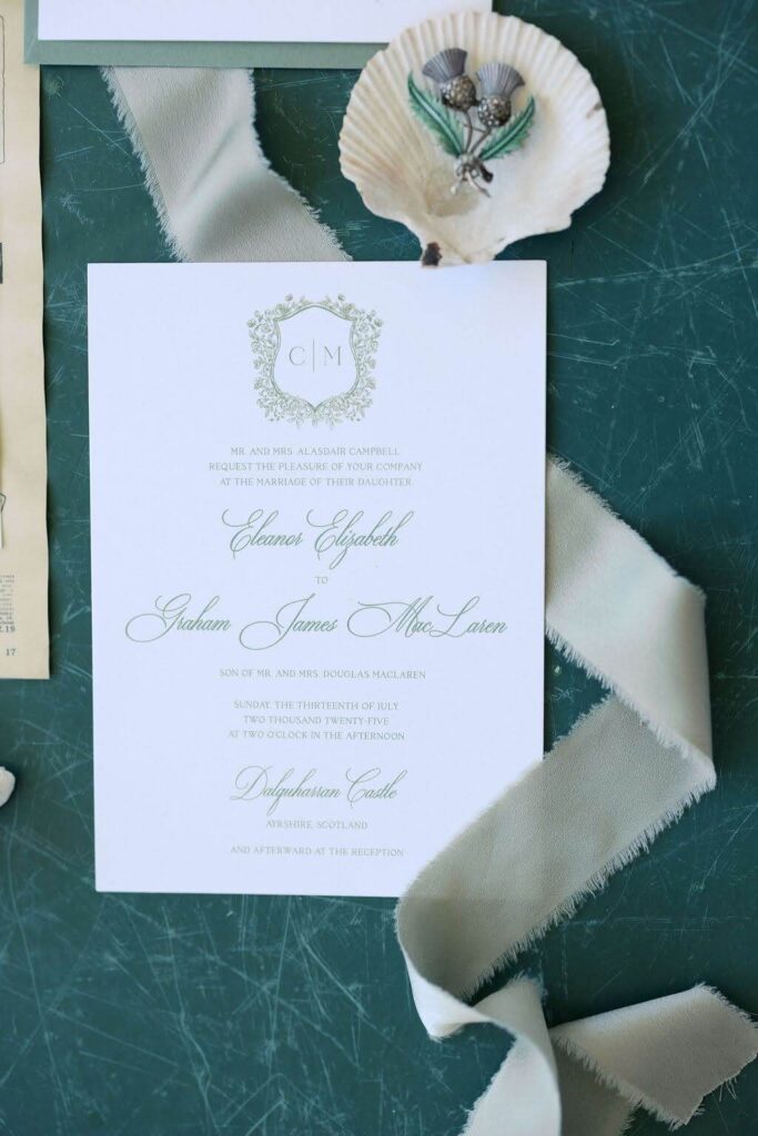 White and green wedding invitation card with custom thistle crest and elegant script