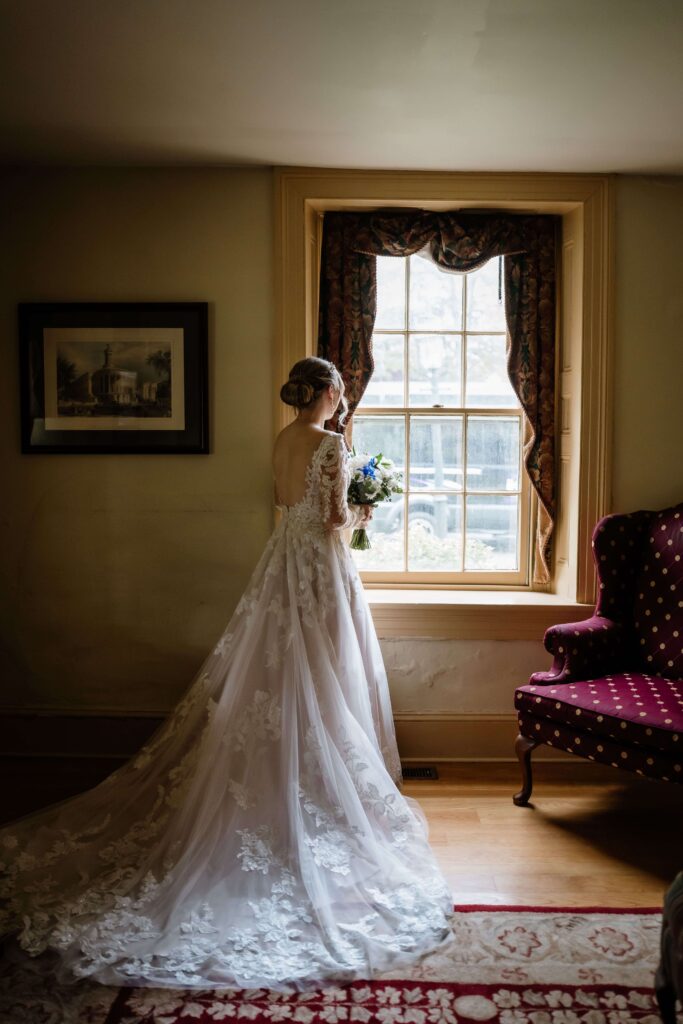 Bridal portrait looking out the mirror of the Joseph Ambler Inn
