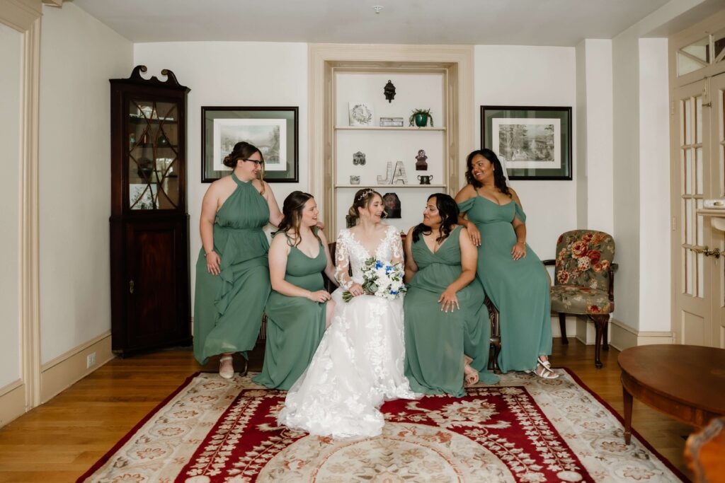 Bride with her bridesmaids inside the Joseph Ambler Inn. The bridesmaids are wearing eucalyptus green dresses.